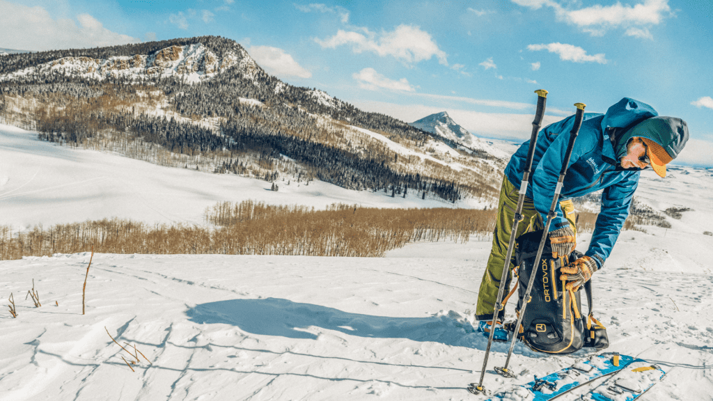 A man with skis on a snowy slope.