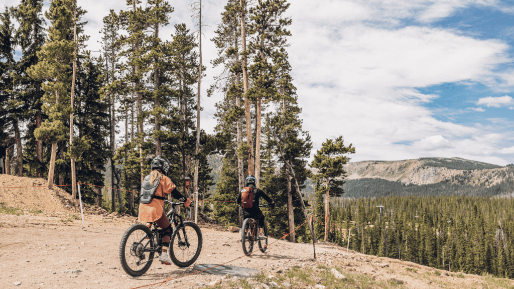 Two mountain bikers riding down a trail in Grand County wearing helmets