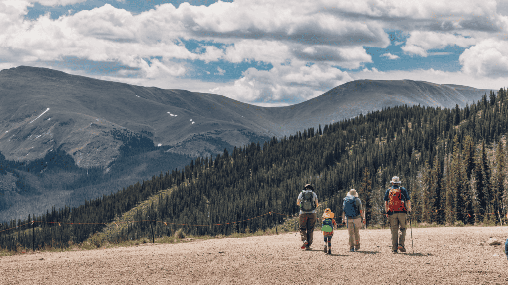 A group of people walking on a dirt road.