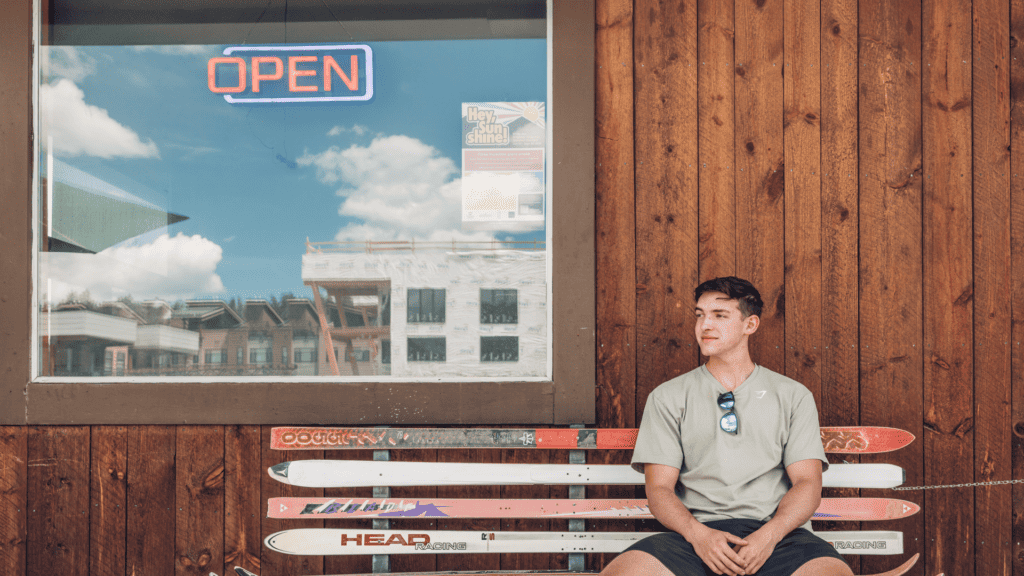 A young man sitting on a ski bench in Grand County, Colorado—one of the town's hidden gems and a unique local spot off the beaten path.