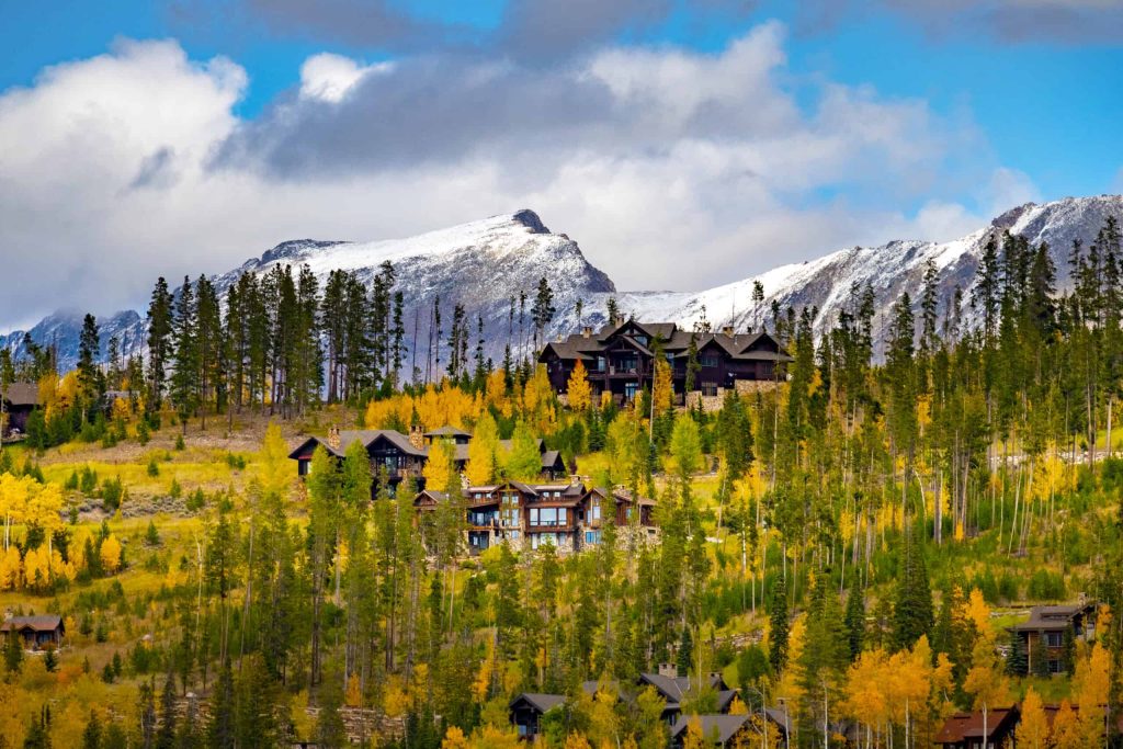 A mountain village is surrounded by trees and mountains.