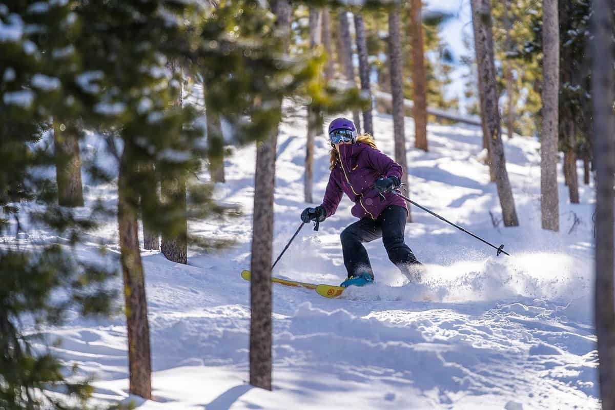 A woman skiing down a snowy trail in Winter Park