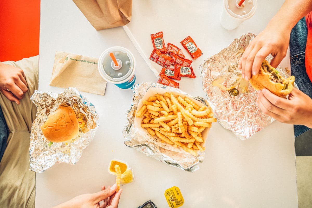 Two people eating burgers and fries at a table at Debbies Drive In in Granby