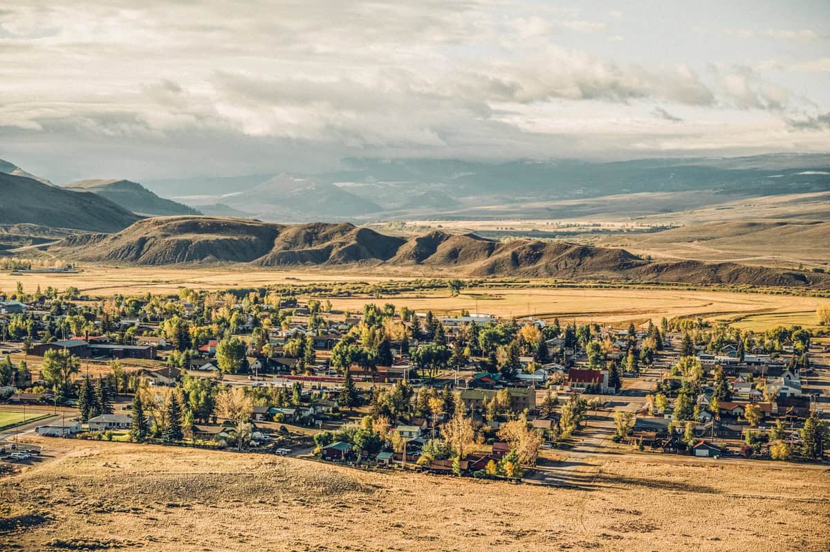 Aerial view of a Kremmling, Colorado. The town is nestled in a valley with surrounding hills and a soft, sunlit landscape.