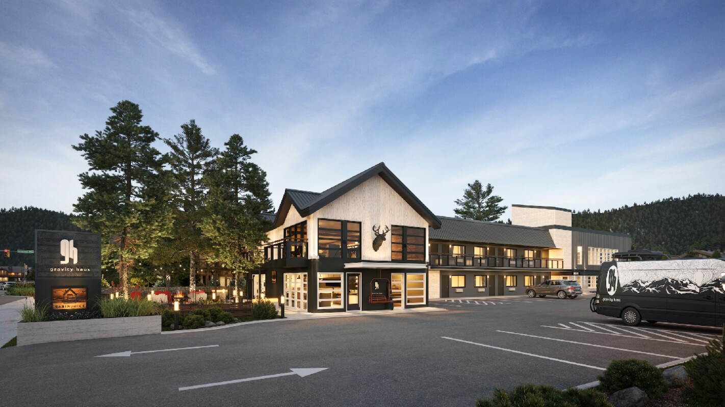 Modern mountain lodge with large windows, deer head sign, and parking lot in Grand County Colorado.