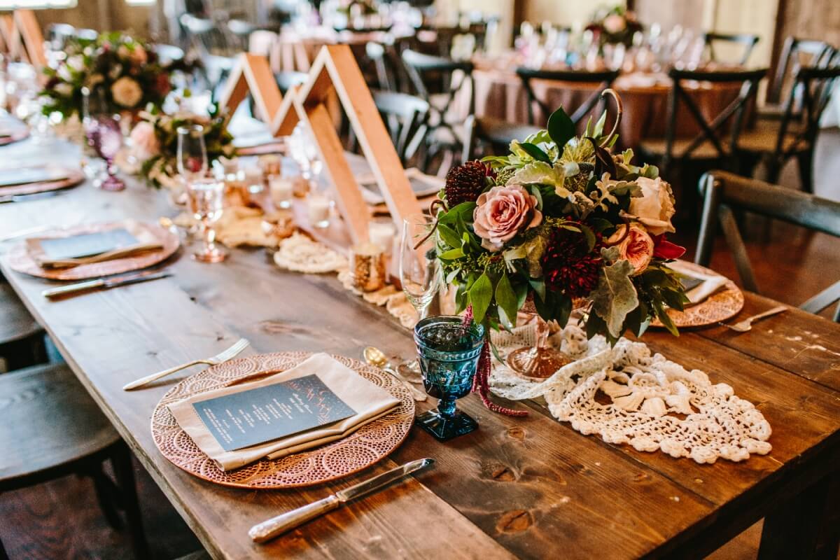 Elegant rustic wedding table setting with lace, flowers, and copper plates in Grand County Colorado.