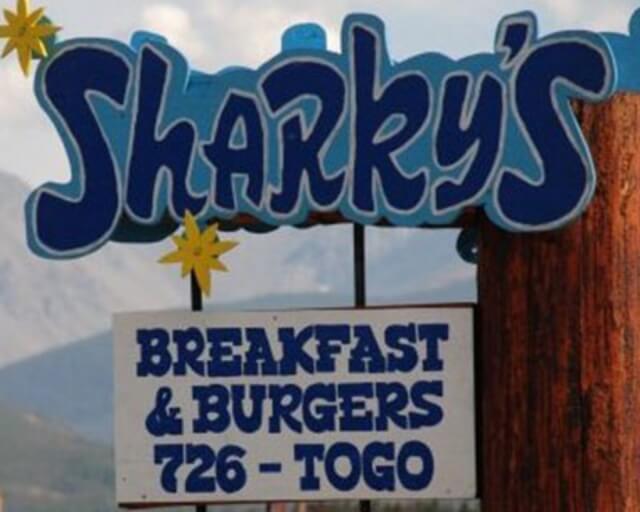 A colorful sign for Sharky's restaurant advertising breakfast and burgers in Grand County Colorado.