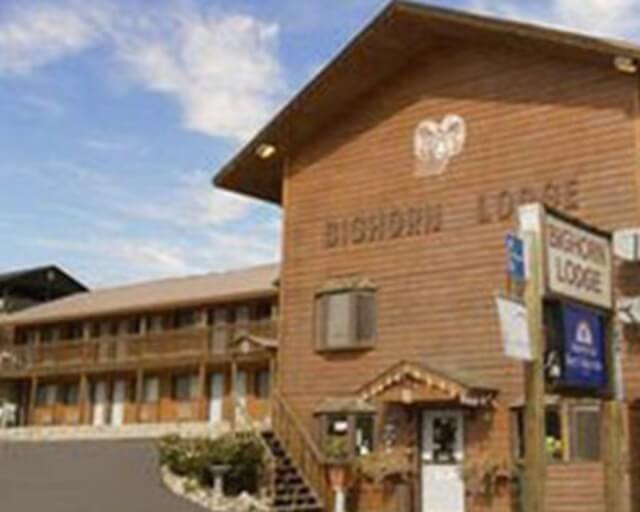 A rustic wooden lodge with a steep roof and a sign reading 'Bighorn Lodge' on the front in Grand County Colorado.