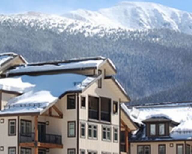 Snow-covered mountain resort with multiple buildings and a backdrop of snow-capped peaks in Grand County Colorado.