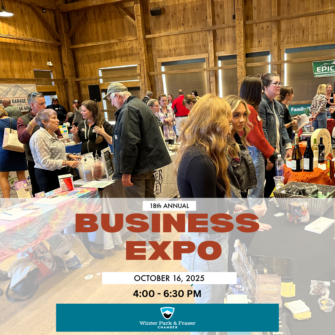 Crowded indoor event with tables and people socializing, likely a business expo in Grand County Colorado.