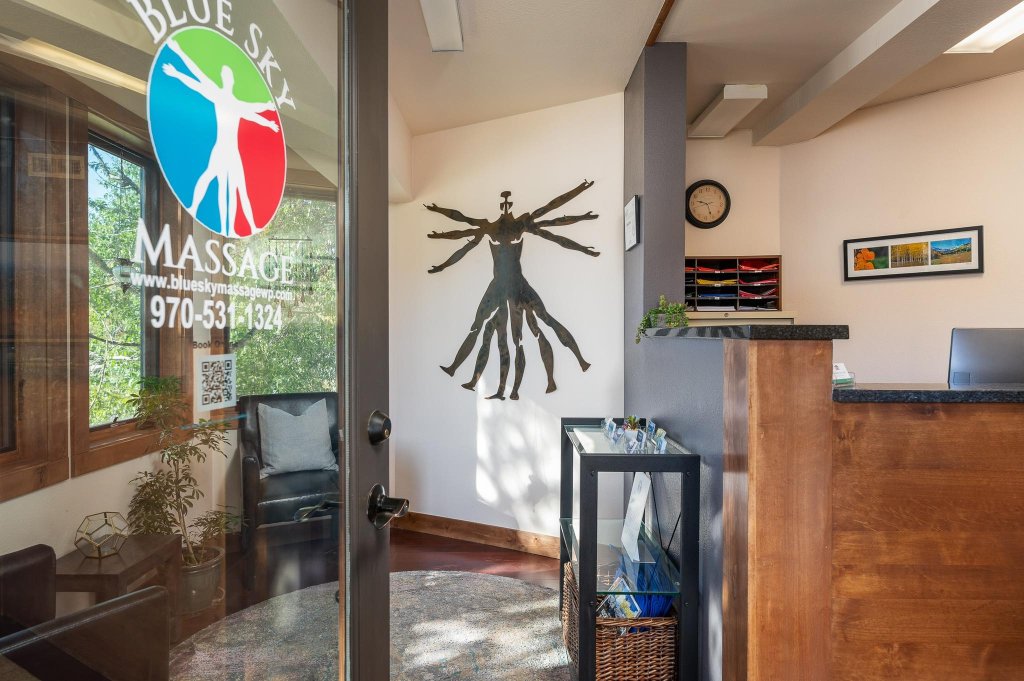 The reception area at Blue Sky Massage with the front desk, seating, and spa signage.