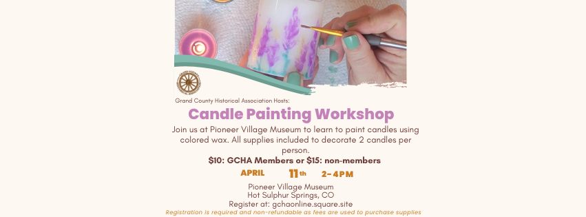 A hand paints a candle with purple and blue hues at a candle painting workshop hosted by the Grand County Historical Association at the Pioneer Village Museum in Hot Sulphur Springs, CO in Grand County Colorado.