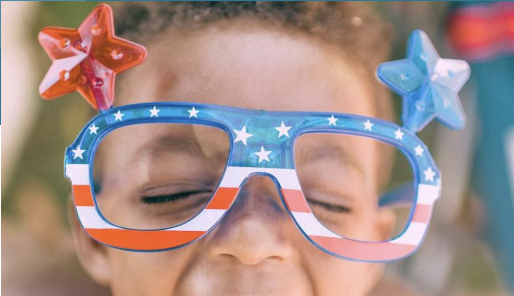 A young child wearing patriotic star-shaped sunglasses with red, white, and blue stripes in Grand County Colorado.