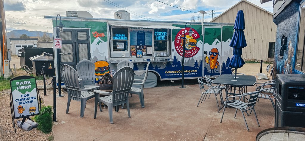 An outside view of the Colorado Corndog & Burger Company food truck and outdoor seating.