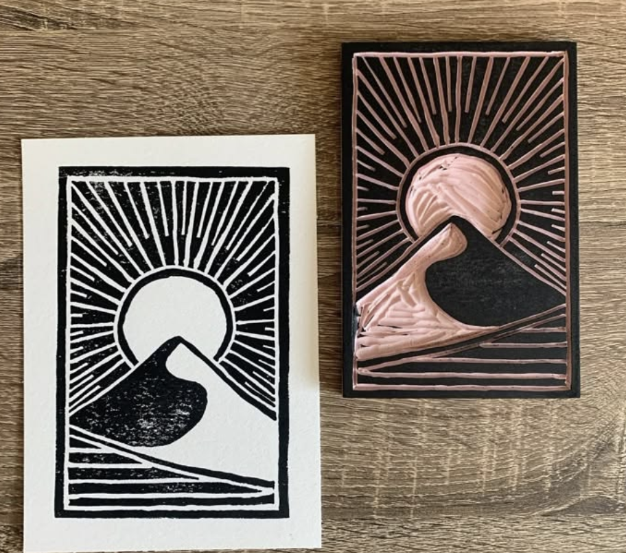 A linocut print of a sun over a dune next to its carved block in Grand County Colorado.