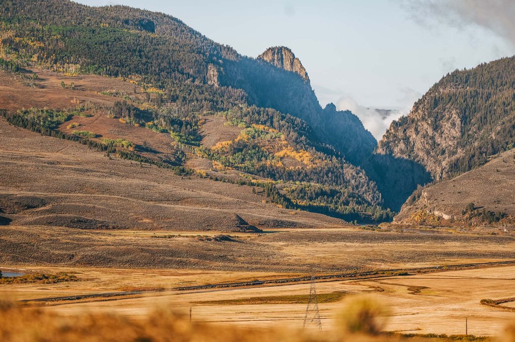 Wide-open mountain valley with rugged cliffs and rolling hills near Kremmling, Colorado.