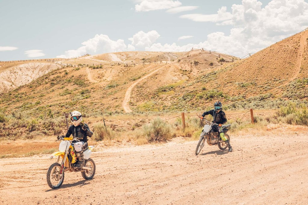 Two dirt bike riders traveling along an off-road trail through the open mountain landscape near Kremmling, Colorado.