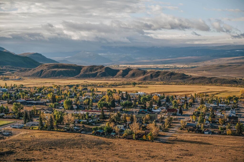 Kremmling nestled in a valley surrounded by rolling hills and autumn trees in Grand County Colorado.